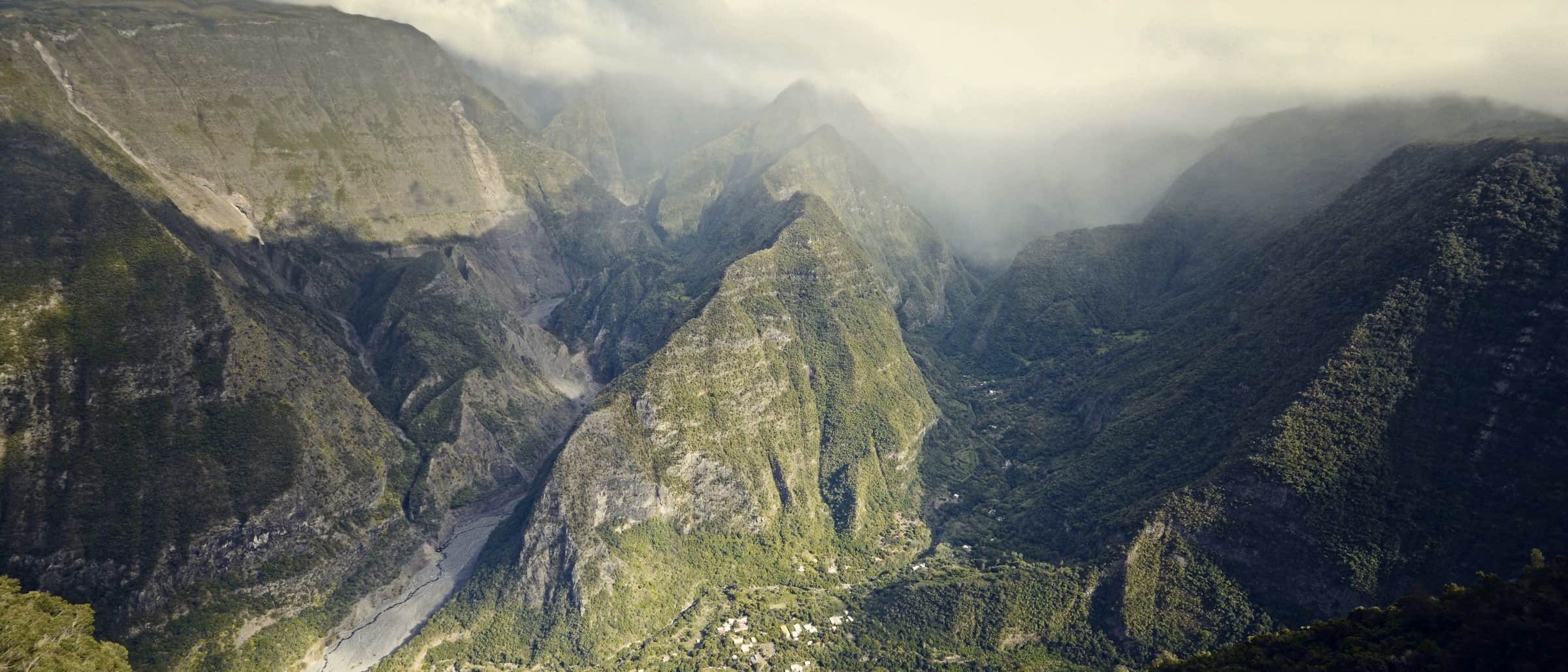 Cloud pouring over steep green valleys and ridges near Cusco, Peru